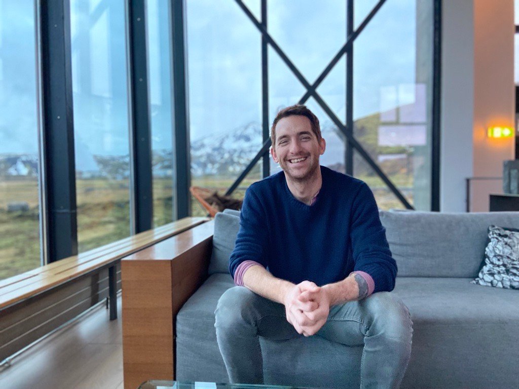 Sean P. Finelli smiling, seated in a lounge with mountain views